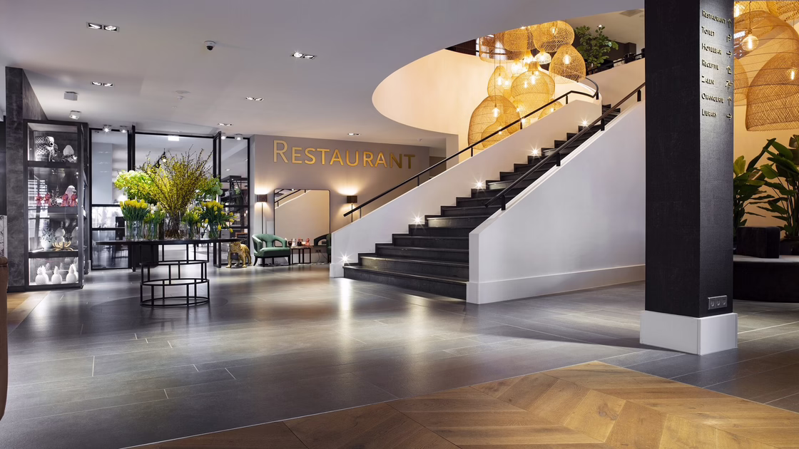 The spacious entrance area with a view of the stairs and the restaurant entrance