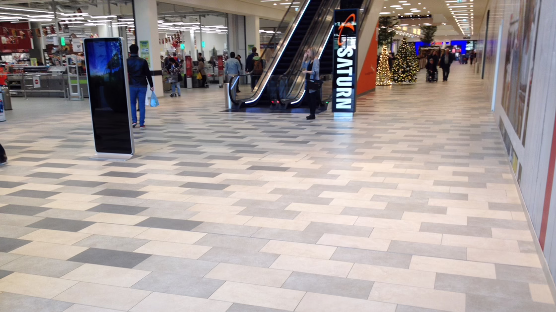The newly laid floor of the shopping centre with a pattern of white and grey tiles